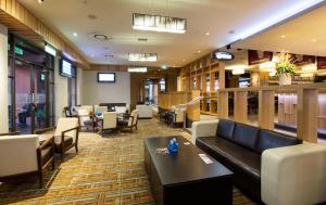 un restaurante con sofá, mesas y sillas en Mermaid Waters Hotel by Nightcap Plus, en Gold Coast