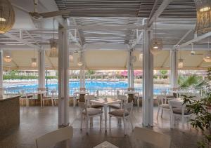 a restaurant with tables and chairs and a pool at Sindbad Club in Hurghada