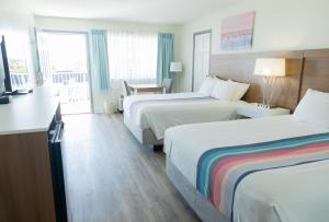a hotel room with two beds and a balcony at Admiral on Baltimore in Rehoboth Beach +15 photos