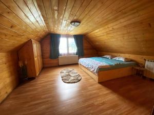 a bedroom with a bed in a wooden room at Casa Mari in Cârțișoara