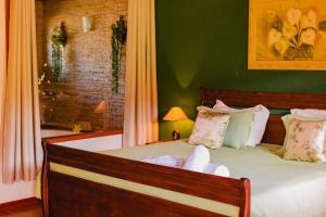1 dormitorio con 1 cama grande y paredes verdes en Pousada do Sonho, en Visconde De Maua