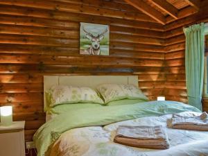 a bedroom with a bed with a deer on the wall at Forest View in Strathyre