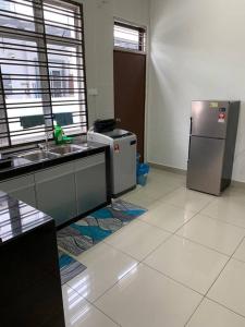 uma cozinha com um frigorífico, um lavatório e um fogão em Hud hud Homestay Gelang Patah em Nusajaya