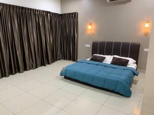 una camera con un letto e una coperta blu di Hud hud Homestay Gelang Patah a Nusajaya
