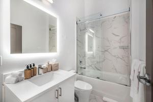 a white bathroom with a sink and a shower at Exhibit A2 in Ann Arbor