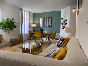 salon z kanapą i stołem w obiekcie Appartement moderne en plein centre D'Epernay w Épernay