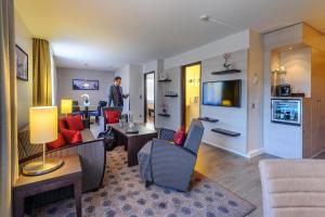 a man is standing in a living room at Mercure Hotel München Süd Messe in Munich