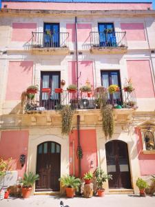 シラクーサにあるFamily apt by Dimore in Sicilyのピンクの建物