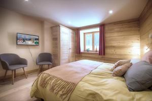 a bedroom with a bed with two chairs and a window at La Ferme des Fingères in Cordon