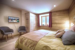 una camera da letto con un letto con due sedie e una finestra di La Ferme des Fingères a Cordon