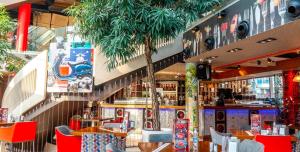 a restaurant with tables and chairs and palm trees at Spacious Apartment next to South Park Просторен Апартамент до Южен Парк Top Location in Sofia