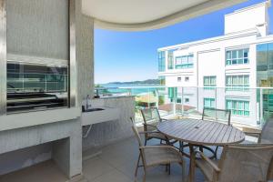 balcón con mesa y sillas y vistas a un edificio en Costa do Sol 203 - Cobertura Duplex em Mariscal - Jacuzzi - Vista para o Mar, en Bombinhas