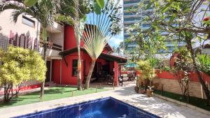 a resort with a swimming pool in front of a building at Hotel Pousada Bossa Nova in Maceió