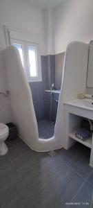 a white bathroom with a sink and a toilet at Tinos apartments Zalonis in Agios Ioannis Tinos