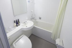 a white bathroom with a sink and a toilet at Shizutetsu Hotel Prezio Shizuoka-Ekikita in Shizuoka