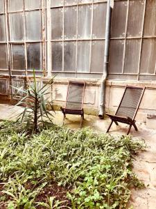 two benches sitting in front of a building at Le Pari Nîmois, avec Parking, Centre Ville Arènes in Nîmes