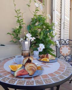 a table with plates of bread and fruit on it at Ballerina Bianca bed & breakfast in Grottazzolina