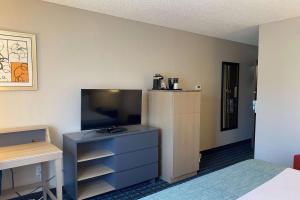 a room with a bed and a television and a dresser at Wingate by Wyndham Chandler Phoenix in Chandler