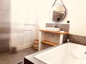 a bathroom with a sink and a mirror at Le Pari Nîmois, avec Parking, Centre Ville Arènes in Nîmes