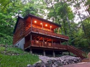 a large wooden house with a deck in the woods at Hygge Up North Cabin in Traverse City