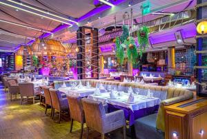 a restaurant with tables and chairs and purple lighting at Spacious Apartment next to South Park Просторен Апартамент до Южен Парк Top Location in Sofia