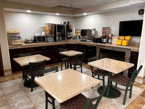 a restaurant with tables and chairs and a kitchen at SureStay Hotel by Best Western Morganton in Morganton