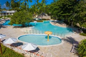 a large swimming pool with chairs and an umbrella at Impressive Punta Cana - All Inclusive in Punta Cana