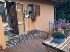 un porche de una casa con un banco y flores en B/B Casa Angela, en Firenzuola