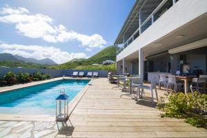 a swimming pool with chairs and a table on a building at Villa Jwi Lavi Boutique Hotel in Saint Martin
