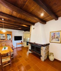 sala de estar con chimenea de piedra y mesa en House Suestellas, en Teulada