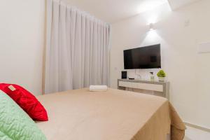 a bedroom with a bed and a flat screen tv at JB03 Flat Cocoon a 250m da Praia de Jaguaribe in Salvador