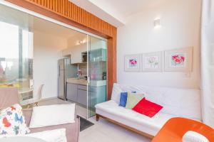 uma sala de estar com um sofá branco e uma cozinha em JB03 Flat Cocoon a 250m da Praia de Jaguaribe em Salvador
