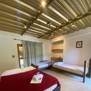 1 dormitorio con 2 camas y techo de madera en Bao Bao Hostel, en Palomino