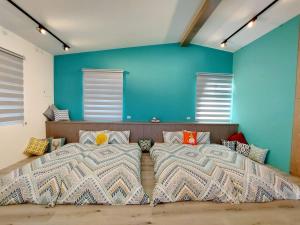Duas camas num quarto com paredes e janelas azuis em 宜蘭五結羅東 田中268 em Yilan City