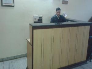 a man standing behind a counter in a room at Hotel Sagar in Agra