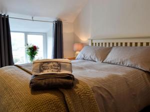 a bedroom with a bed with a pillow on it at Bryn Hyfryd in Llanrwst