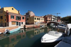 Kilka łodzi zakotwiczyło w kanale. w obiekcie Ricco di comfort, grande, luminoso e comodo w Wenecji