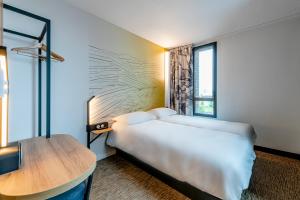a hotel room with a bed and a table at B&B HOTEL Dreux Nord in Dreux