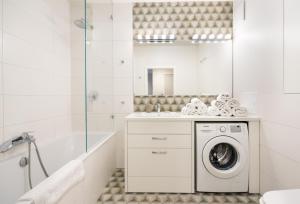 Baño blanco con lavadora en un lavabo en Sokratesa Estate Ideal Apartment, en Varsovia