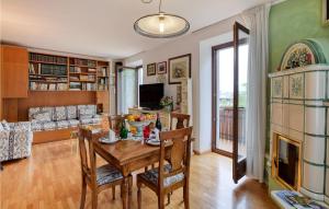 sala de estar con mesa, sillas y chimenea en Amazing Apartment In Comano Terme With House A Mountain View, en Comano Terme