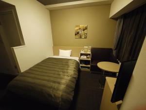 Rúm í herbergi á Hotel Route Inn Minami Yokkaichi