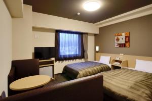 Rúm í herbergi á Hotel Route Inn Minami Yokkaichi