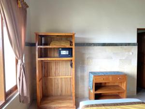 a bedroom with a wooden book shelf and a table at Villa Agung Khalia Ubud in Ubud