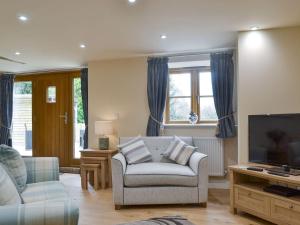 a living room with a couch and a tv at No, 1 Ash Cottage in Quatt