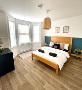 a bedroom with a large bed with a wooden headboard at Central, Bright & Spacious Apartment - Parking Included in Bournemouth