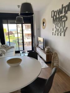 un soggiorno con tavolo e sedie bianchi di Precioso apartamento con terraza y piscina en Portonovo-Sanxenxo a Portonovo