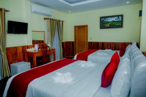 a hotel room with two beds with red pillows at Mohasal Angkor Boutique in Siem Reap