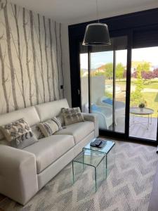 a living room with a white couch and a table at Precioso apartamento con terraza y piscina en Portonovo-Sanxenxo in Portonovo