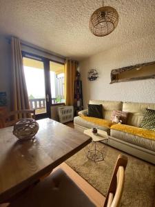 a living room with a couch and a table at Laye station - les Arolles A - 4 personnes in Laye