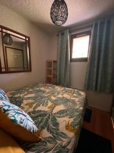 a bedroom with a bed and a mirror and a window at Laye station - les Arolles A - 4 personnes in Laye